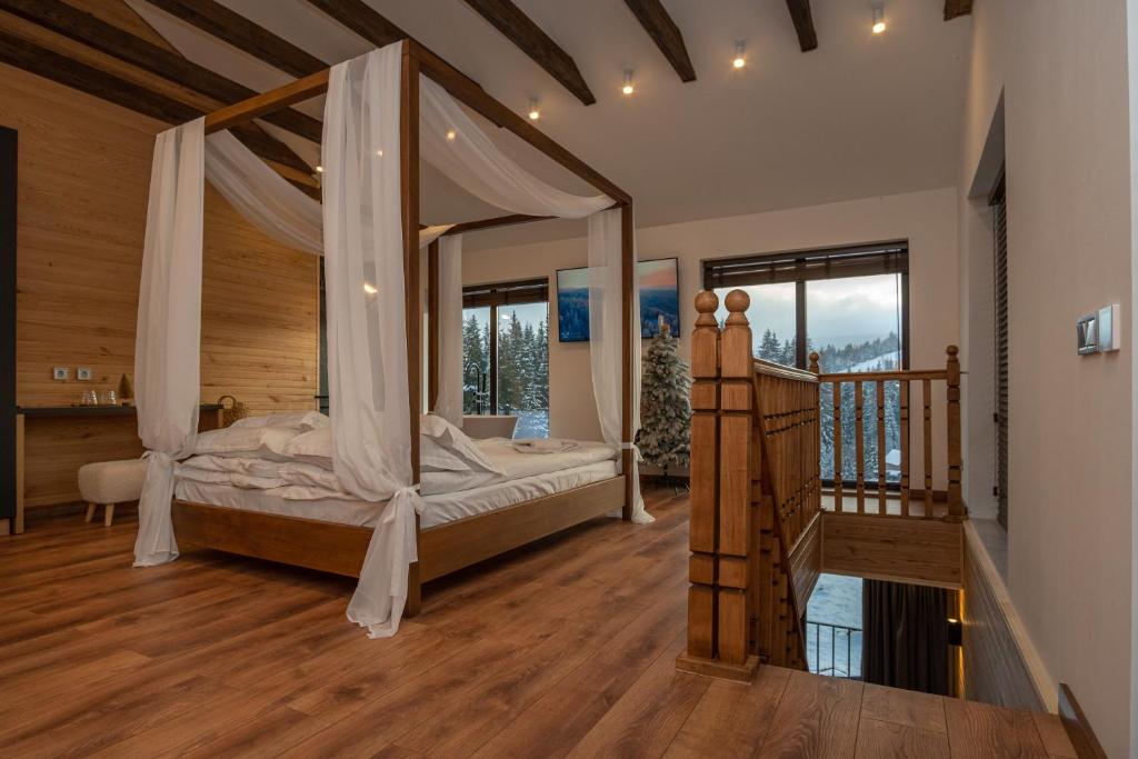 a bedroom with a canopy bed and a staircase at Chillax Chalet in Yablunytsya