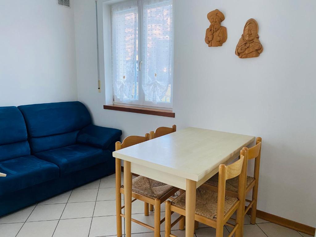 un soggiorno con tavolo e divano blu di La Rocchetta, Borgo Valsugana a Borgo