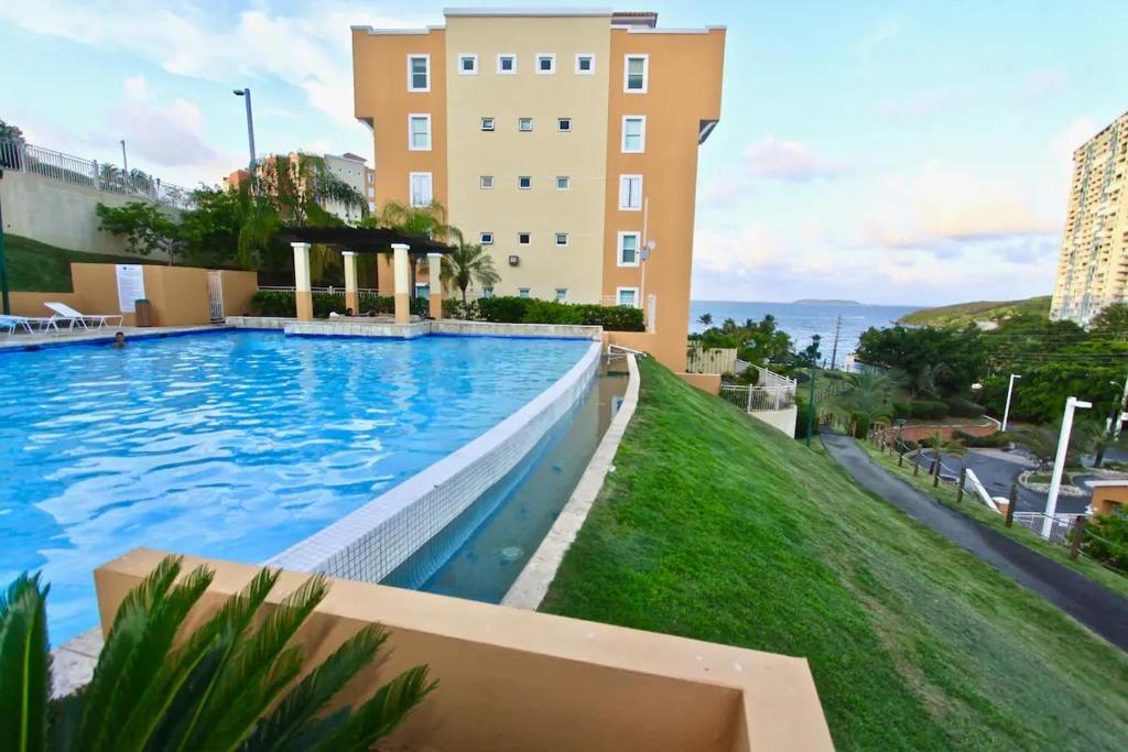a large swimming pool in front of a building at Ocean & Marina Views 3 Bedroom 2 Bathroom Luxury Condo in Fajardo