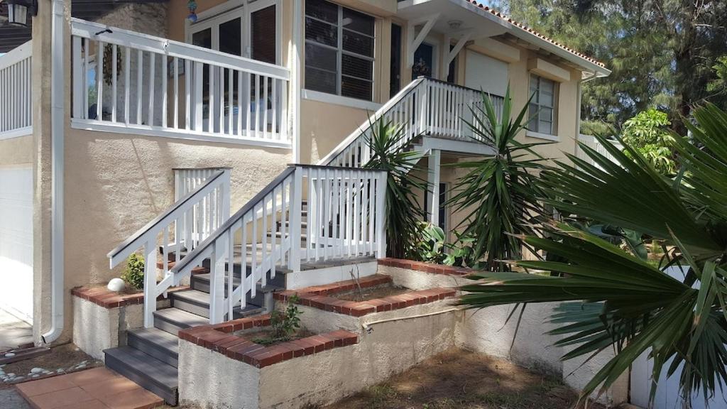 a house with white stairs and a palm tree at Spacious Beach House Unit,Beautifully Furnished 2 Bed 2Bath./2Min.Walk To Beach in Clearwater Beach