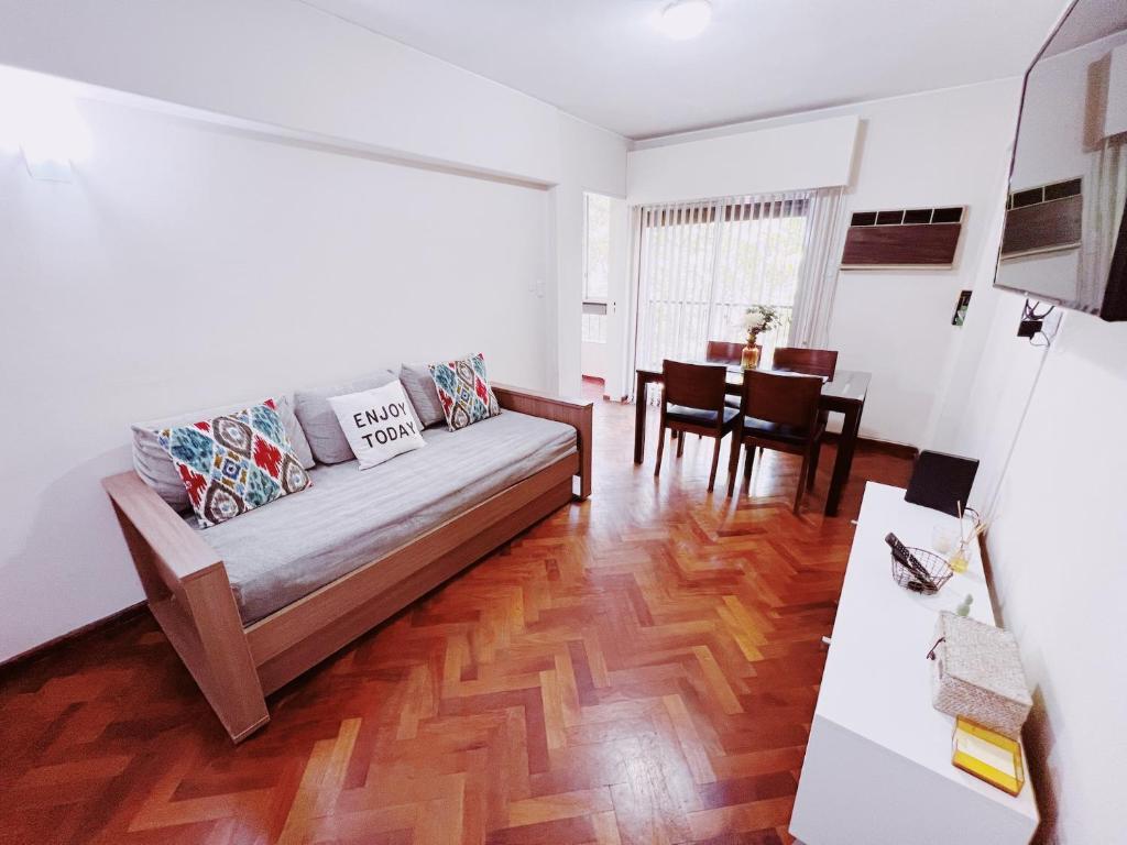 ein Wohnzimmer mit einem Sofa und einem Tisch in der Unterkunft Departamento Peatonal Sarmiento in Mendoza