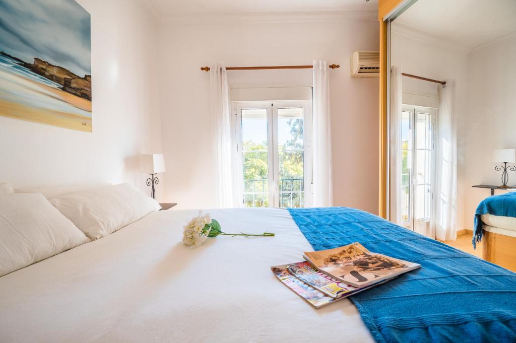 a bedroom with a bed with a magazine and flowers on it at Distinguido y céntrico apartamento en San Bernardo in Seville