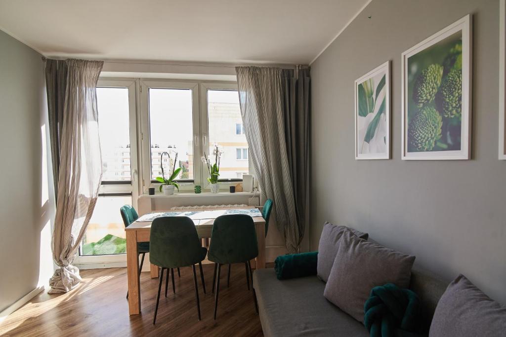 a living room with a table and chairs and a couch at Beautiful view in Gdańsk