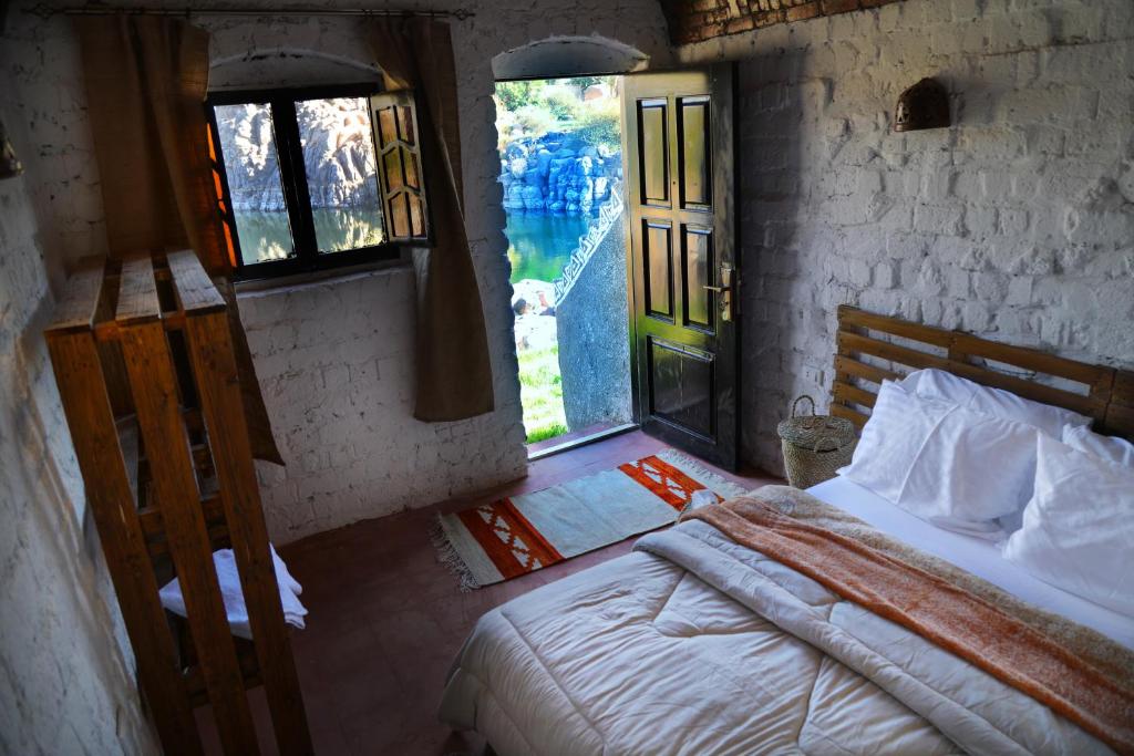 a bedroom with a bed in a room with a window at Krouma Camp & Ecolodge in Naj‘ al Maḩaţţah