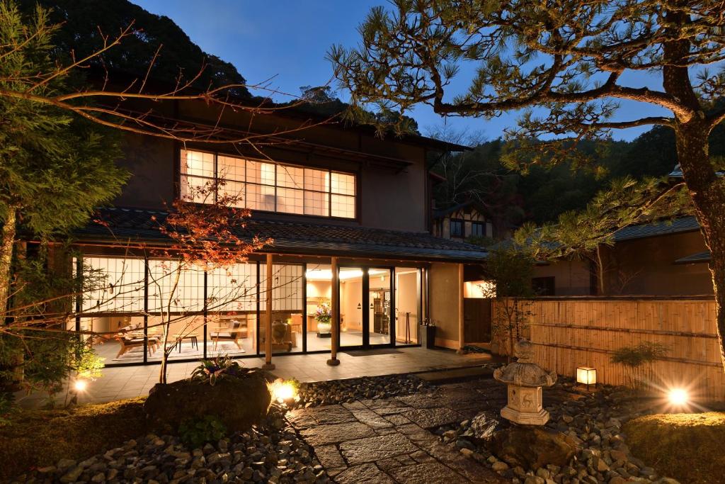 a home with a lit up exterior at night at Oni no Sumika in Izu