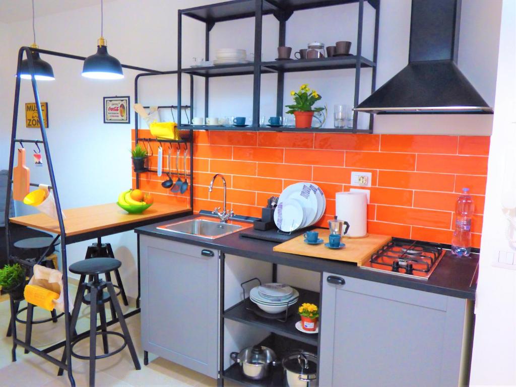 una piccola cucina con parete in mattoni arancioni di Napoletando b&b a Napoli