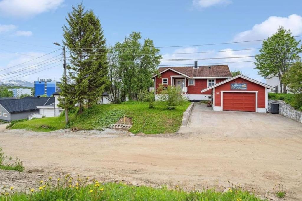 a house with a red garage and a driveway at 36 sqm Studio aparatment B in Tromsø