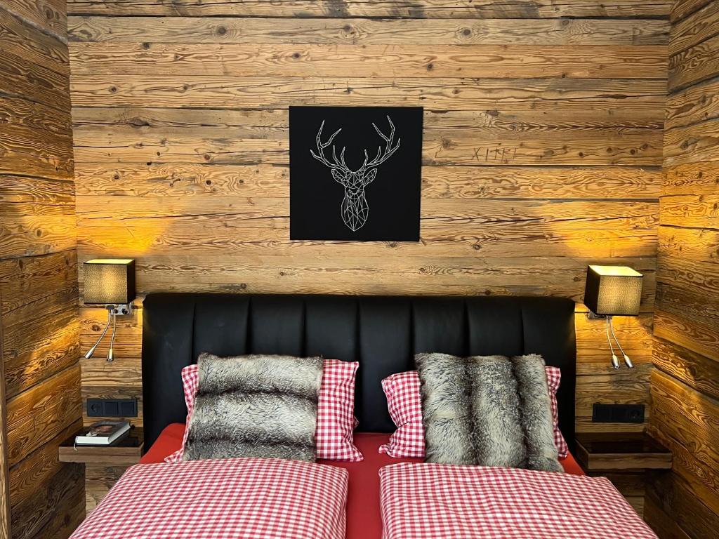 ミッタージルにあるSki-in & Out Alpine Style Apartment near Kitzbühelのベッドルーム1室(赤と白の枕が備わるベッド1台付)