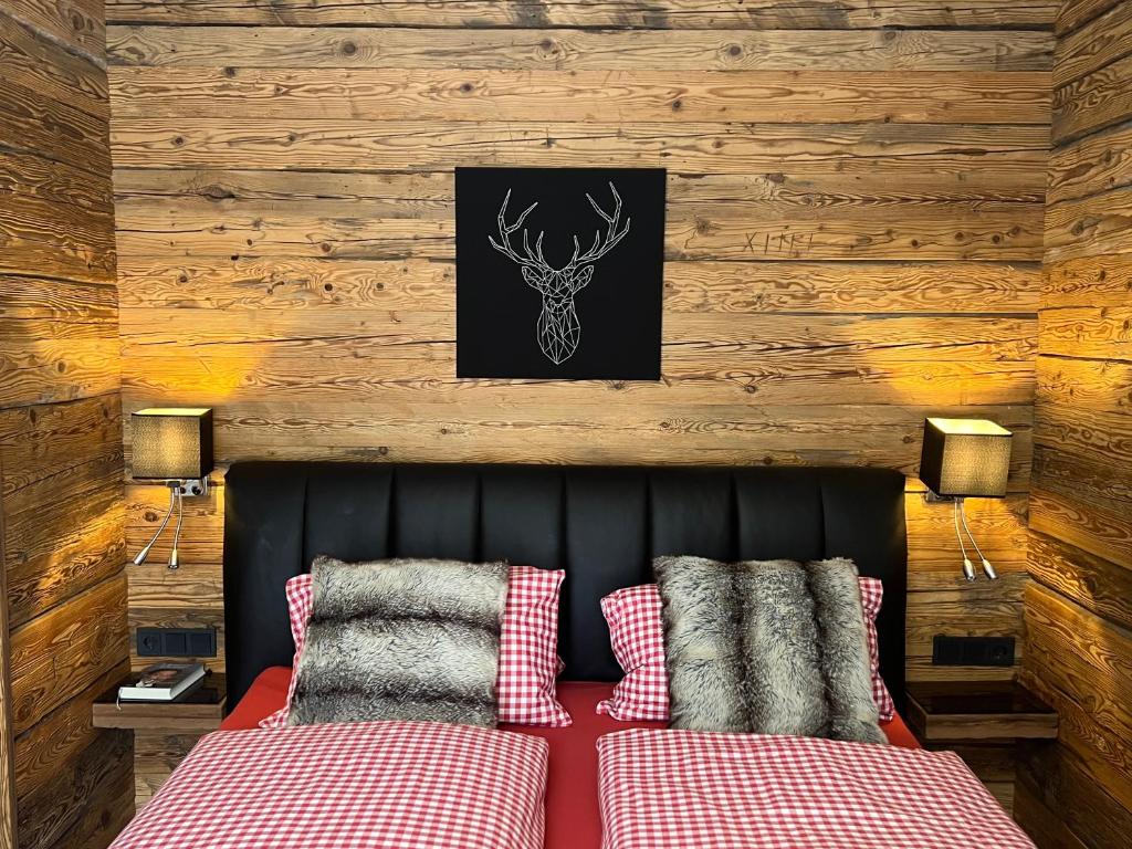 a bedroom with a bed with red and white pillows at Ski-in & Out Alpine Style Apartment near Kitzbühel in Mittersill