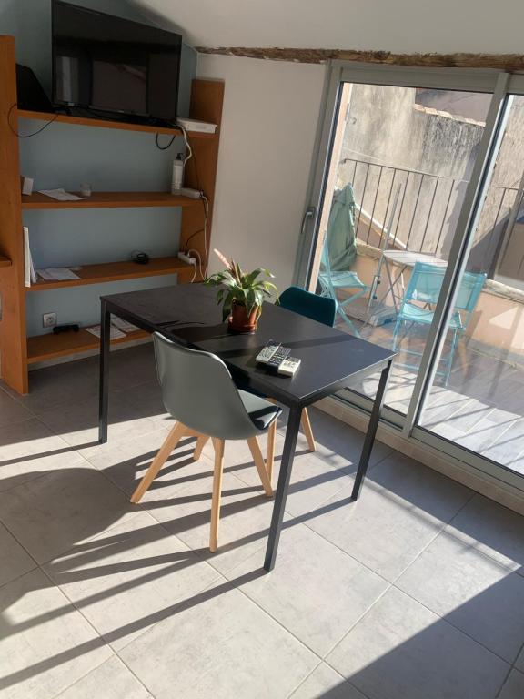 - une table noire et une chaise dans la chambre dans l'établissement Studio avec Terrasse, à Aix-en-Provence