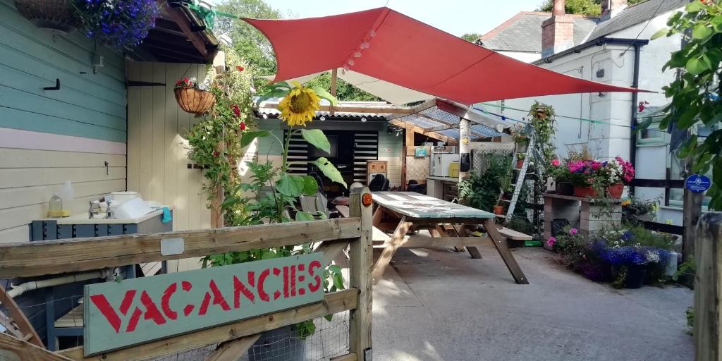 a patio with a table and an umbrella at Eden's Yard Backpackers in St Austell