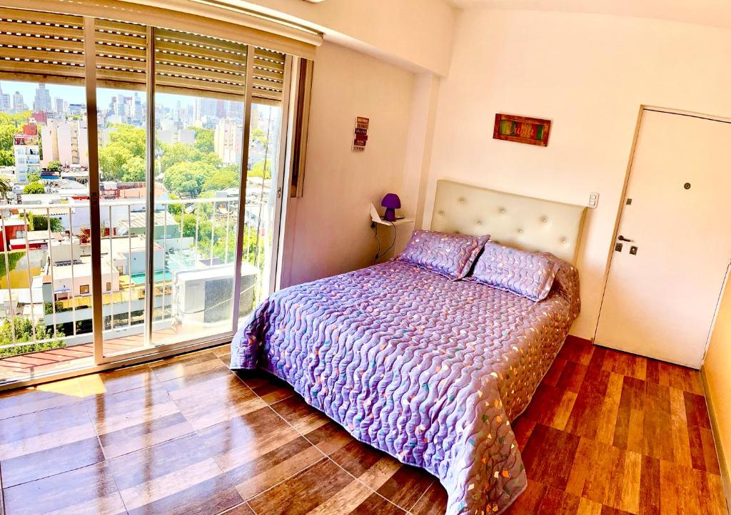 1 dormitorio con cama y ventana grande en Excelente monoambiente en Buenos Aires