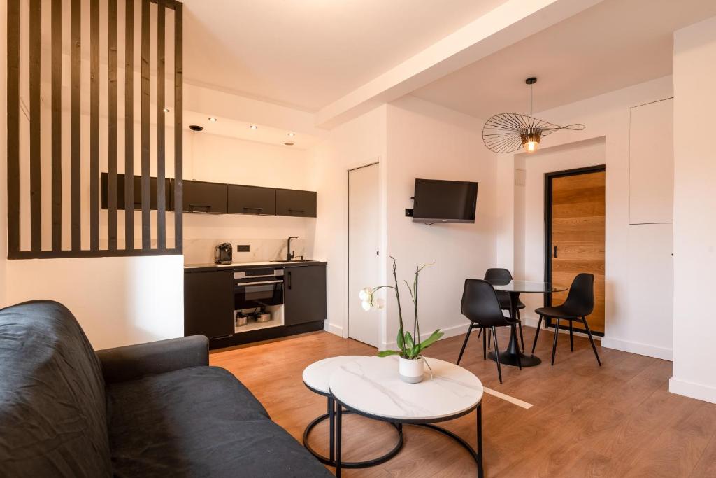 uma sala de estar com um sofá e uma mesa em Appartement Le Médicis - 2 chambres em Rouen