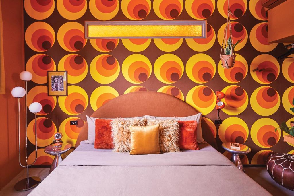 - une chambre avec un lit et un mur coloré dans l'établissement MOOD HAUS by DW, à San Juan