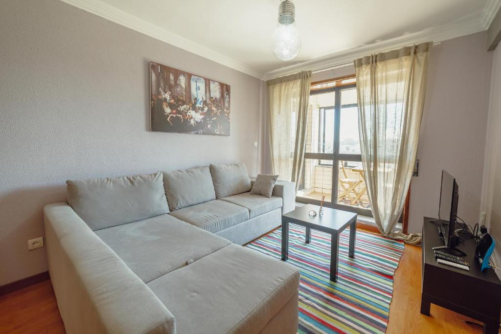 - un salon avec un canapé blanc et une table dans l'établissement Matosinhos Seaside Apartment by Vacationy, à Matosinhos