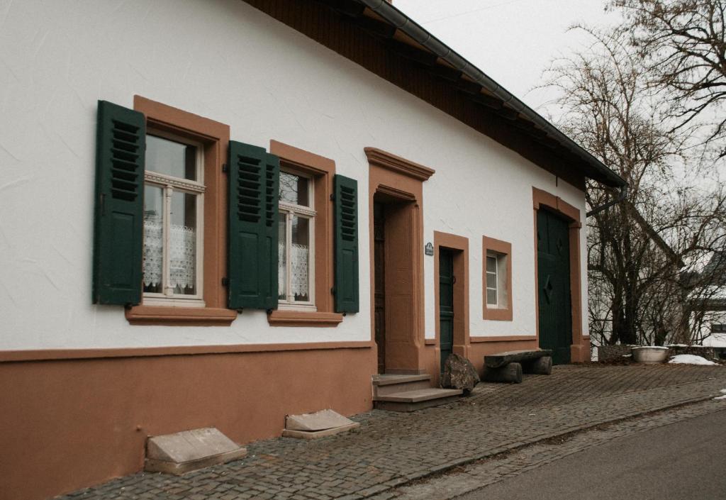 Casa blanca con persianas verdes y puerta en Ferienhaus Anno 1810, en Wadern