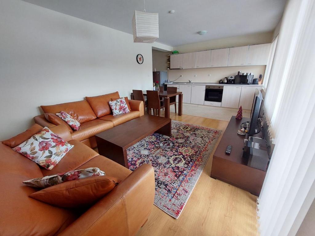 uma sala de estar com um sofá e uma mesa em Apartment Pirin em Bansko