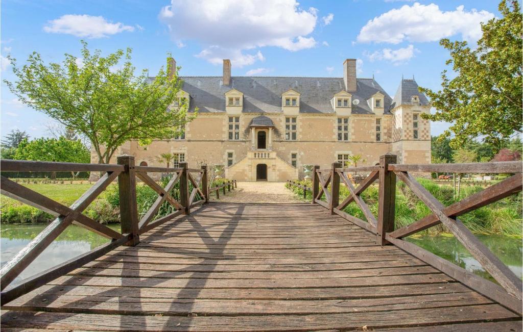 eine Brücke über einen See vor einem Schloss in der Unterkunft 5 Bedroom Nice Home In Fontaine Gurin in Fontaine-Guérin