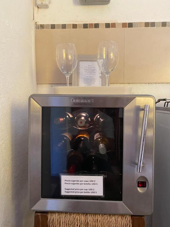 zwei Weingläser und ein kleiner Fernseher mit Maschine in der Unterkunft Casa Calma in Colonia del Sacramento