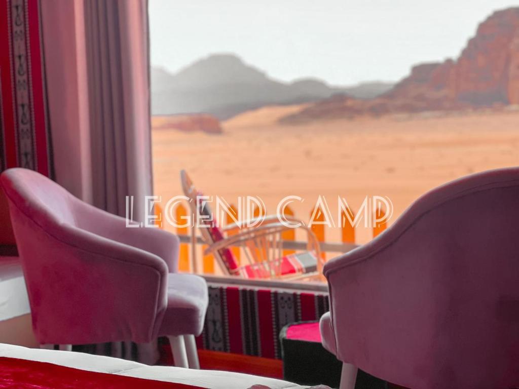 a room with two chairs and a view of the desert at Rum Hatem Camp in Wadi Rum