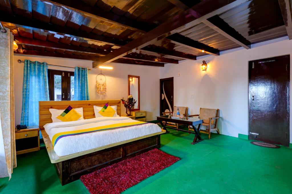 a bedroom with a bed and a desk in it at Itsy By Treebo - Shri Gv Inn 600 Mtrs From Tiffin Top in Nainital
