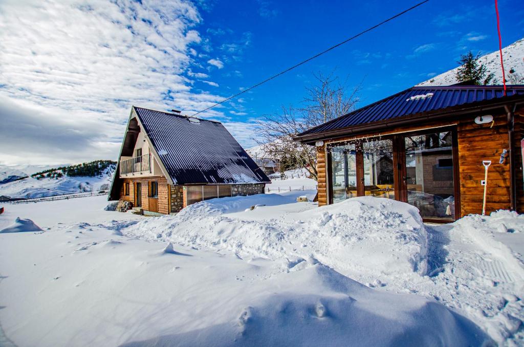 ein Blockhaus im Schnee mit Schnee um ihn herum in der Unterkunft Holiday home Mons Albis Bjelašnica in Bjelašnica