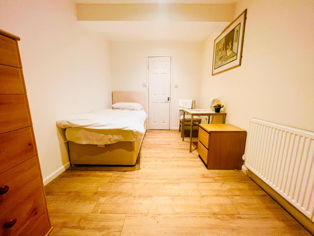 Habitación pequeña con cama y escritorio. en White House Lodge en Cambridge