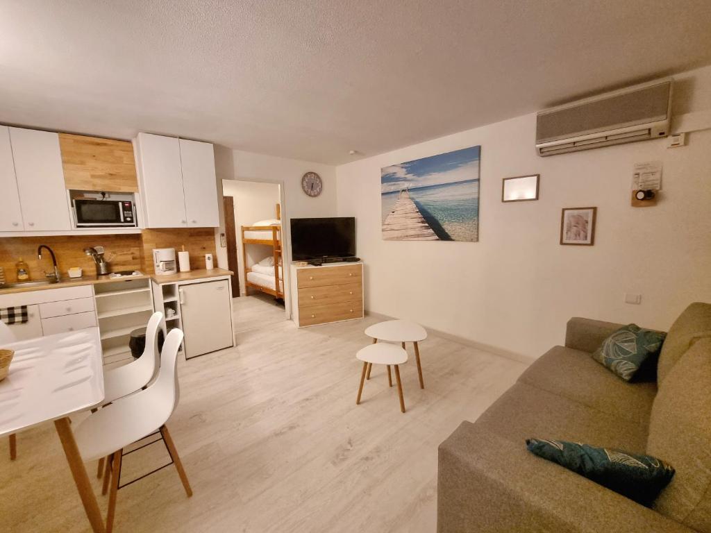 a kitchen and living room with a couch and a table at 100 m de la plage - Les Cigales de Mer - Studio Cabine - Parking in Le Grau-du-Roi