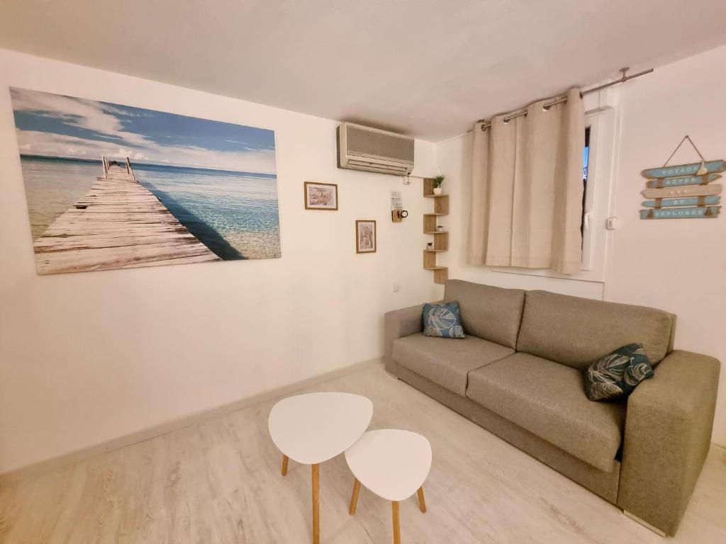 a living room with a couch and a table at 100 m de la plage - Les Cigales de Mer - Studio Cabine - Parking in Le Grau-du-Roi