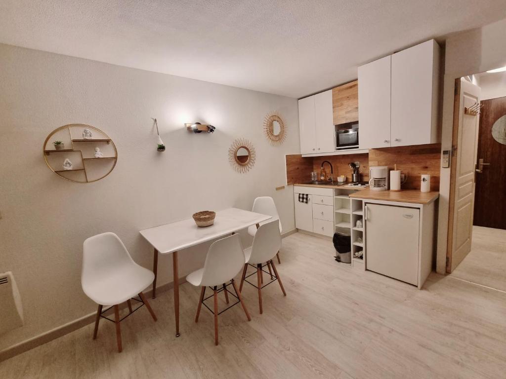 a kitchen with a table and chairs in a room at 100 m de la plage - Les Cigales de Mer - Studio Cabine - Parking in Le Grau-du-Roi