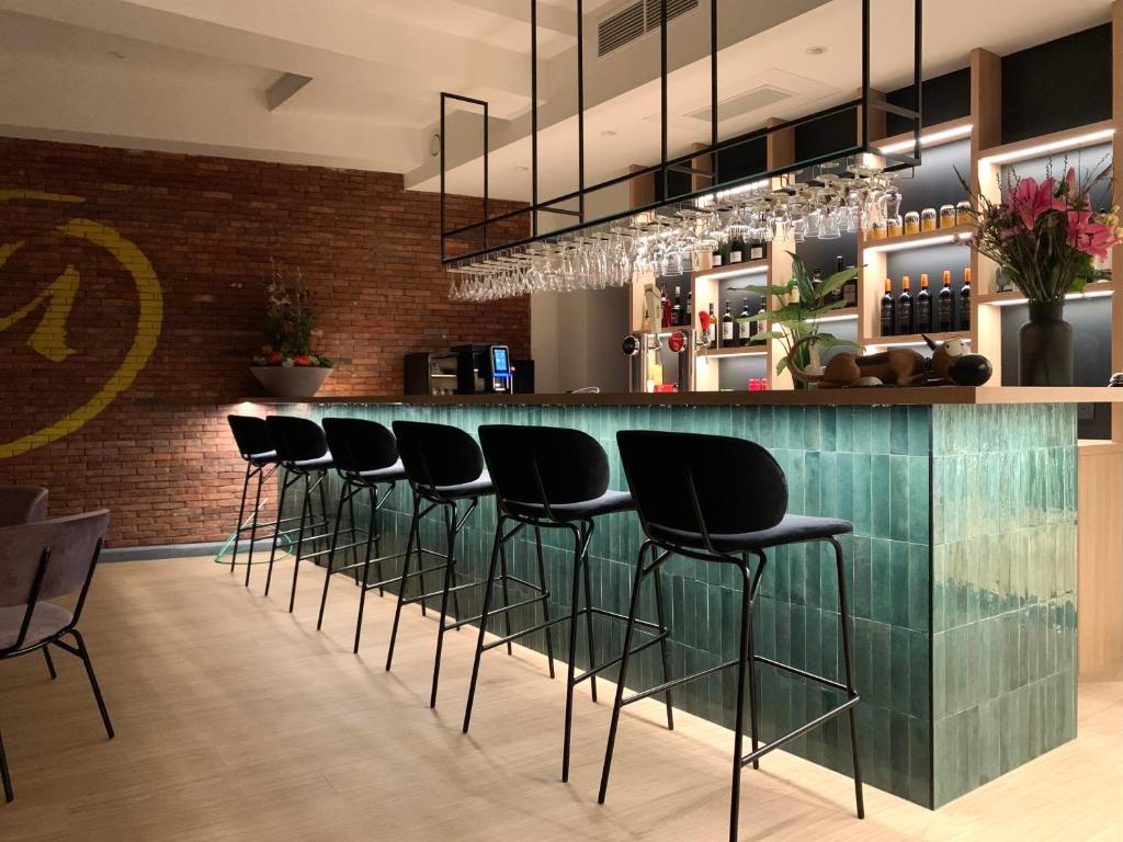 a bar with black stools in a restaurant at Comic Art Hotel in Ghent