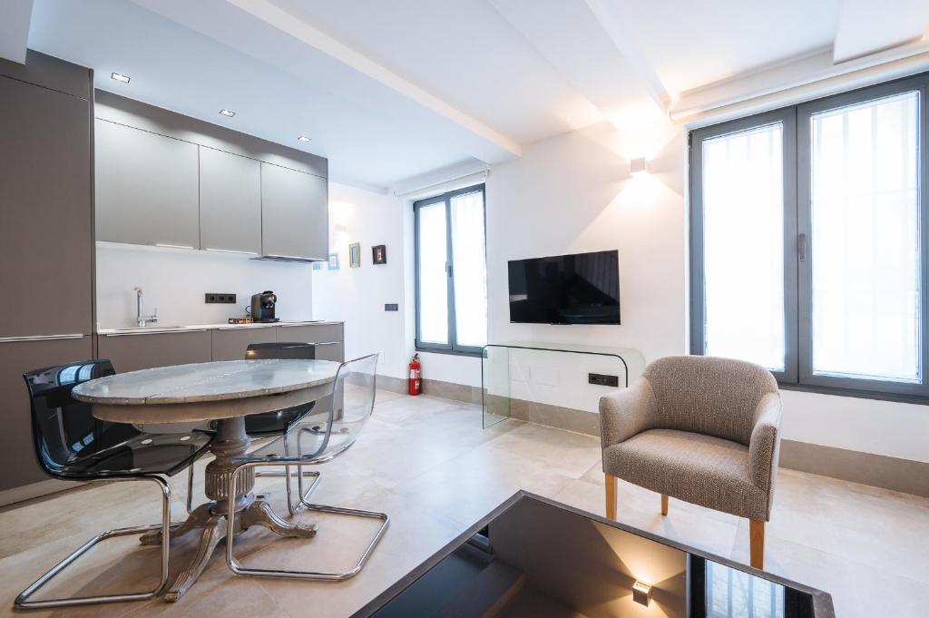 cocina y sala de estar con mesa y sillas en apartamentos montevideo 6, en Sevilla