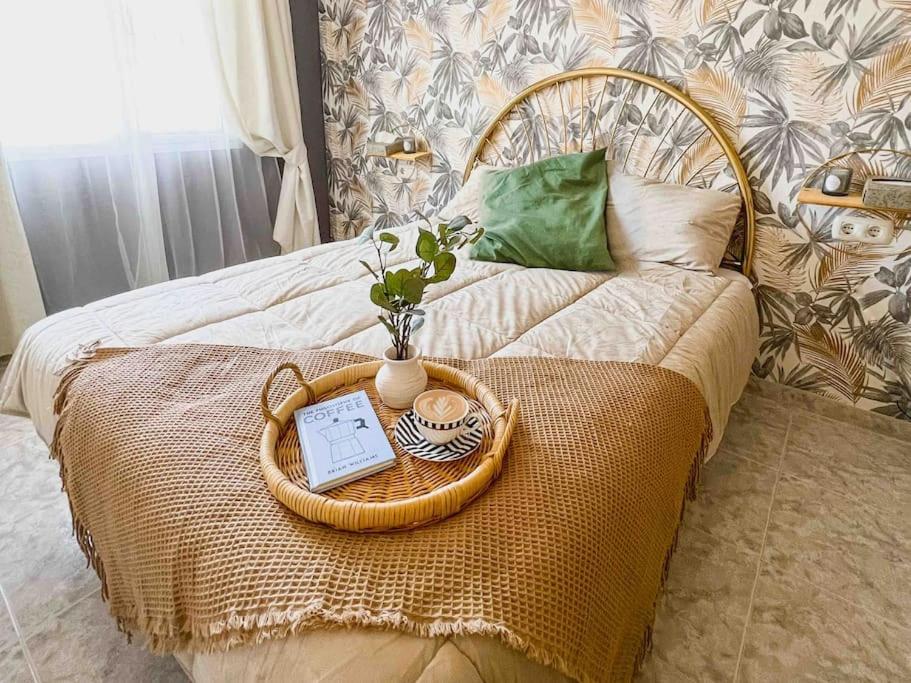 a bed with a tray with a laptop on it at Apartamento moderno y acogedor cerca del mar in Fuengirola