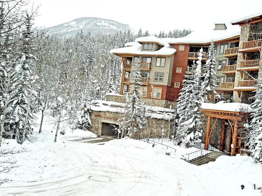 a large building in the snow with trees at Panorama Springs Lodge in Panorama