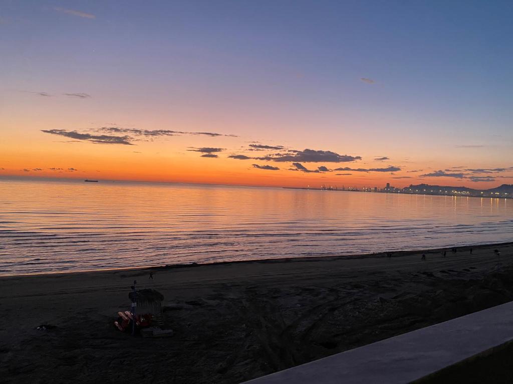 een zonsondergang op een strand met de oceaan bij Beauty-sunset apartment in Durrës