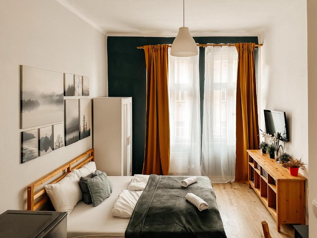 a bedroom with a large bed with orange curtains at Savor Apartment in Prague