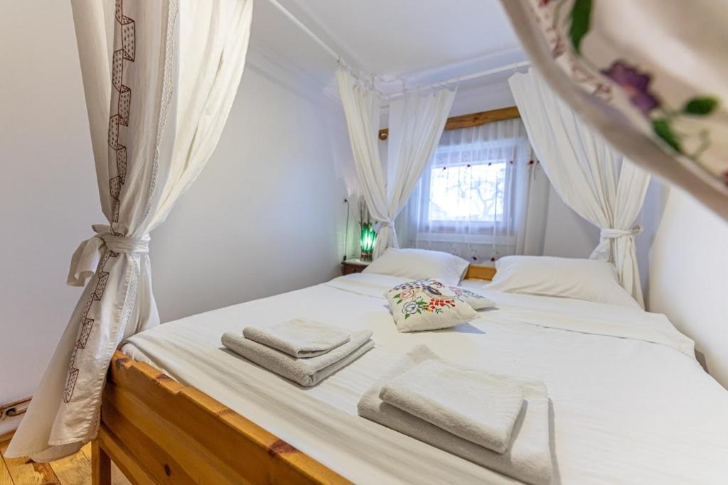 a bedroom with a white bed with towels on it at Holiday Home Captain's Village in Šljivovica