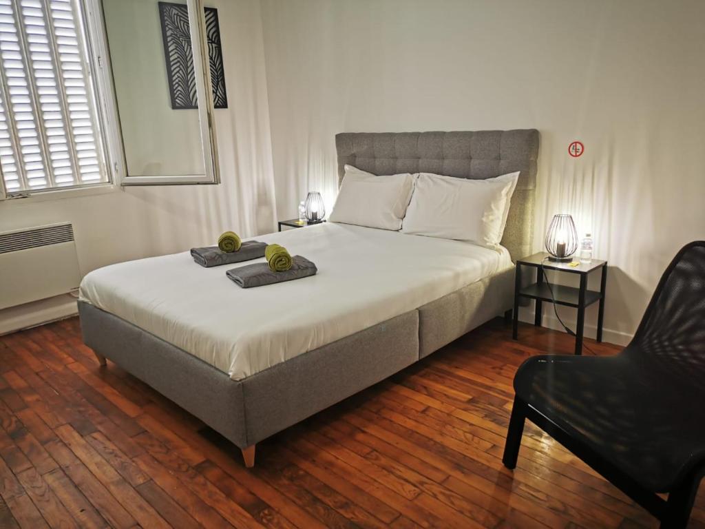1 dormitorio con 1 cama grande y 1 silla en Le Chatoyant, en Melun