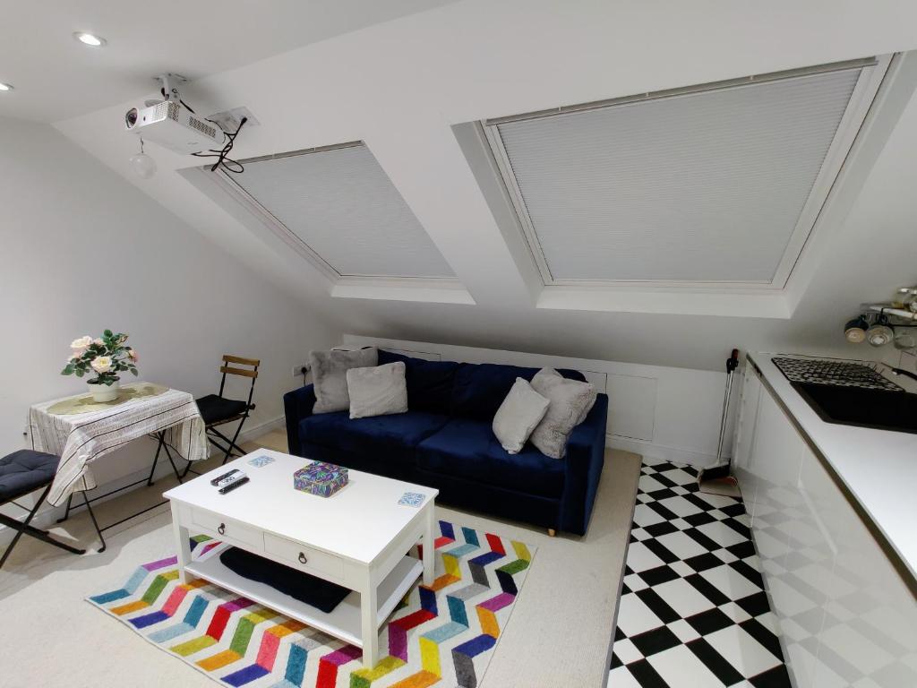 un soggiorno con divano blu e tavolo di Jacuzzi Suite a Londra