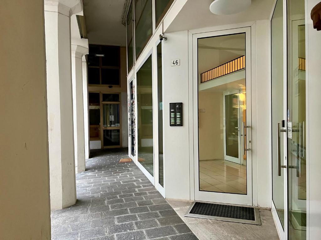 un couloir vide d'un bâtiment avec des portes en verre dans l'établissement Dolada, meraviglia nel centro di Belluno, à Belluno