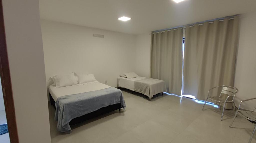 Un dormitorio con 2 camas y una ventana con luces. en Casa do Sérgio, Lindo loft-02 moderno e confortável., en Paraty