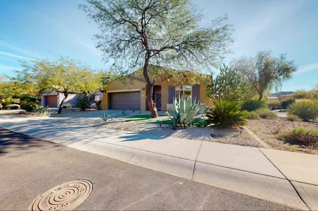 a house with a tree in front of a driveway at NEW! Stunning Peaceful Peoria Home - Very Close to Sports Complex in Peoria