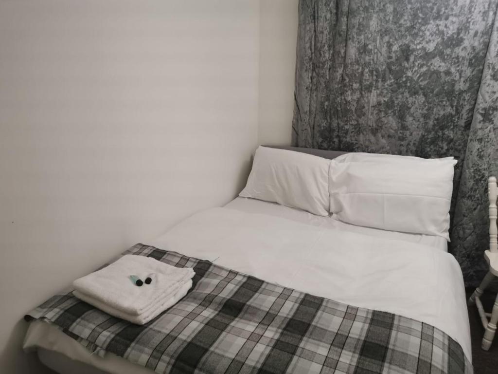 a black and white photo of a bed with a towel on it at Ella's Place in Luton