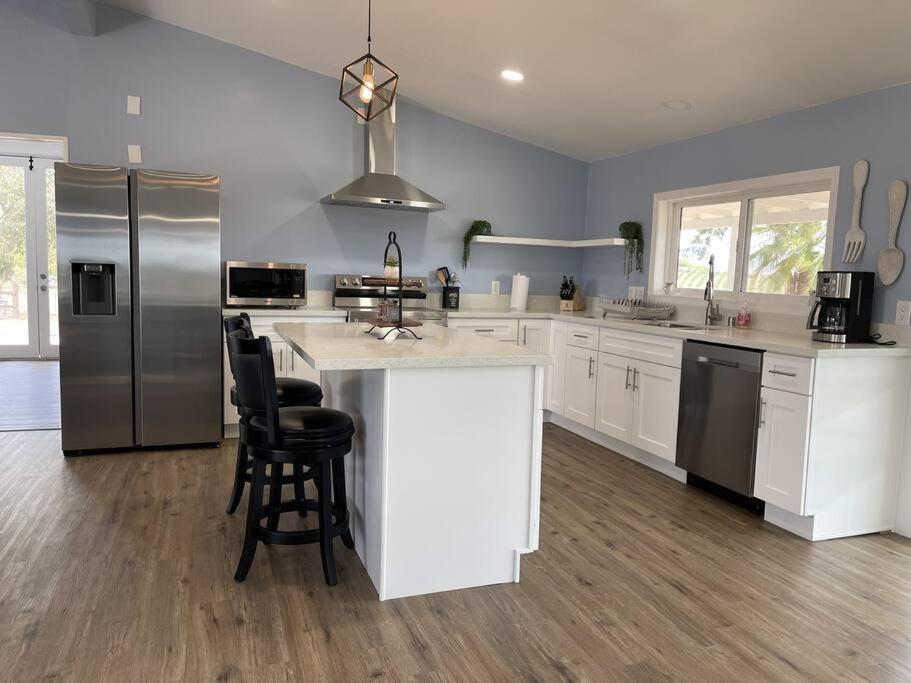 a large kitchen with white cabinets and a large island at Temecula Rejuvenation in Temecula