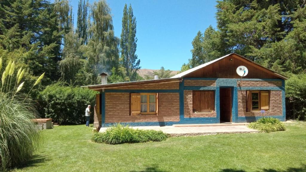 una casa en un jardín con una persona parada frente a ella en Casa Azul en Potrerillos
