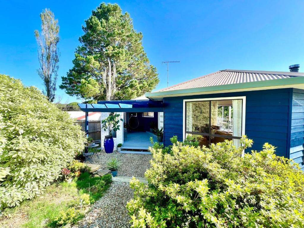 a blue house with a garden in front of it at Blue Lily Bungalow in Katoomba