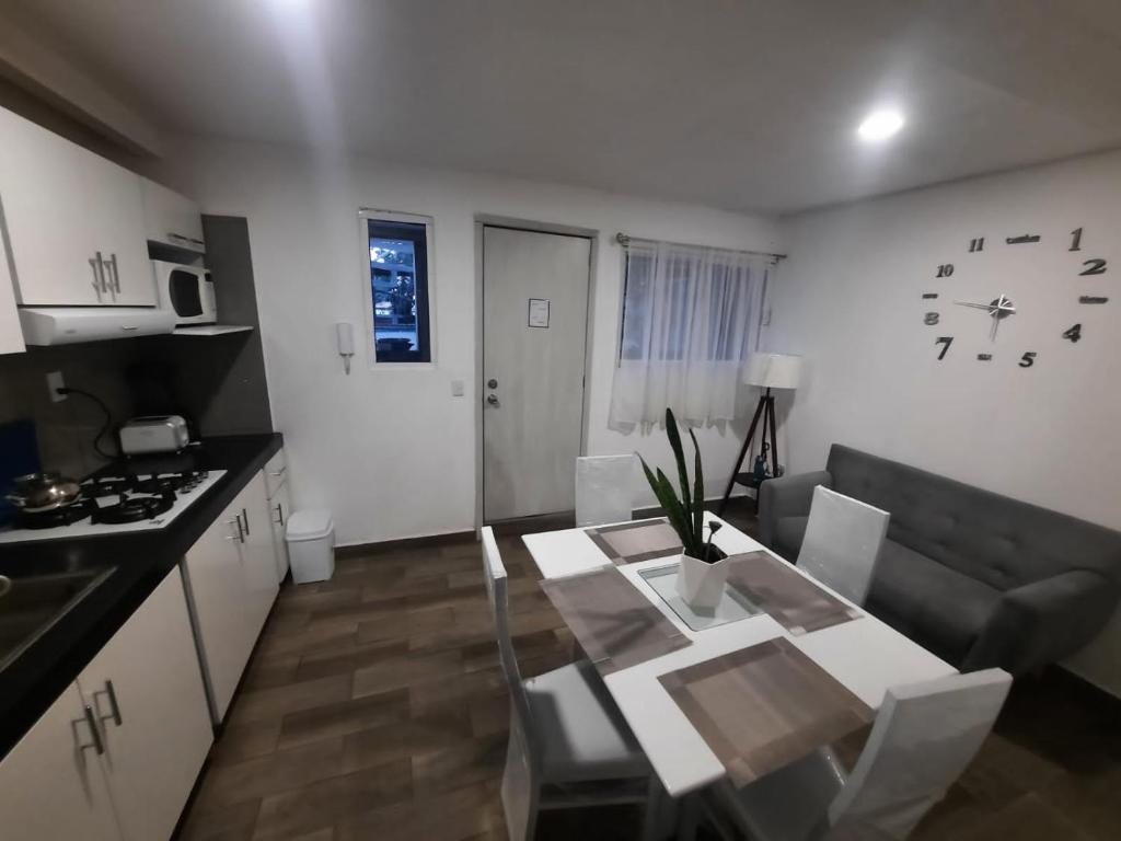 een keuken en een woonkamer met een tafel en een bank bij frida in Mexico-Stad