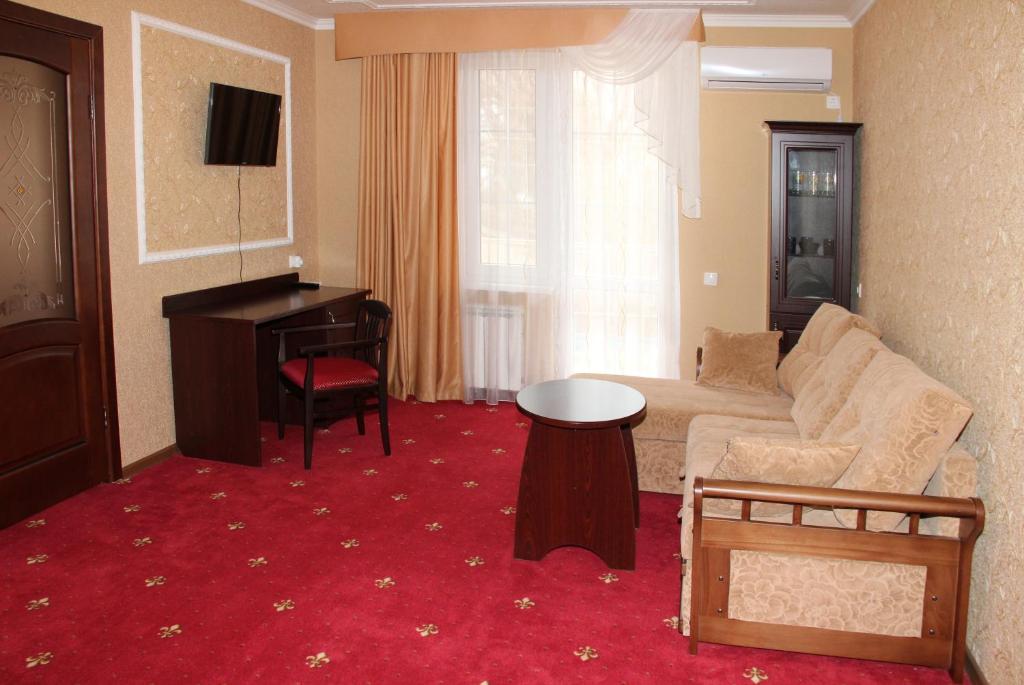 a living room with a couch and a piano at Hotel Premier in Golubitskaya