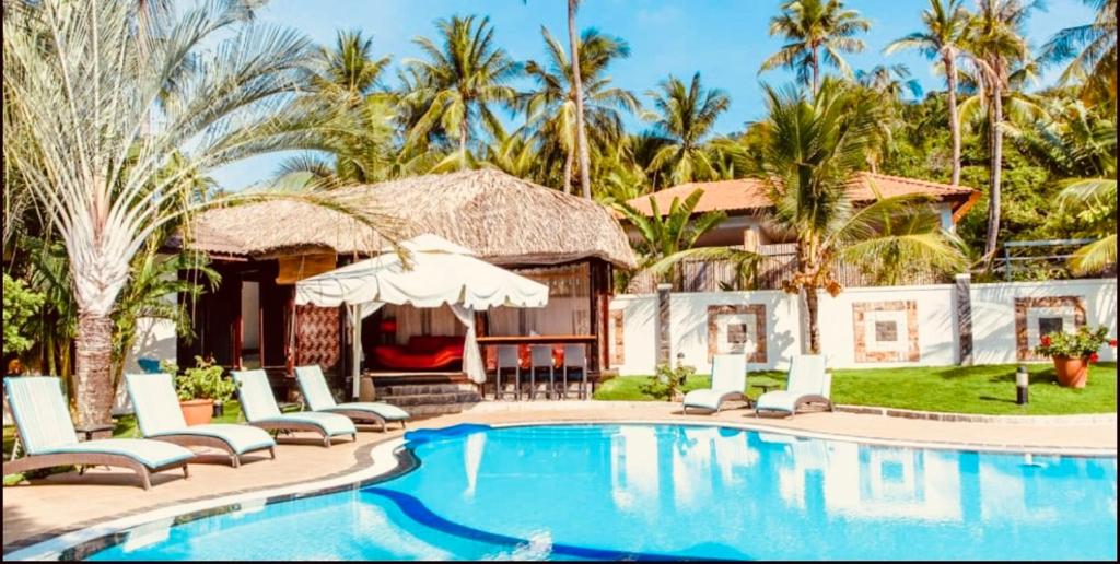 美奈的住宿－Jaguar House Resort Muine，一个带椅子和房子的游泳池的度假胜地
