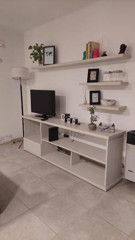 una sala de estar con un centro de entretenimiento blanco con TV en Oikos VM en Villa María